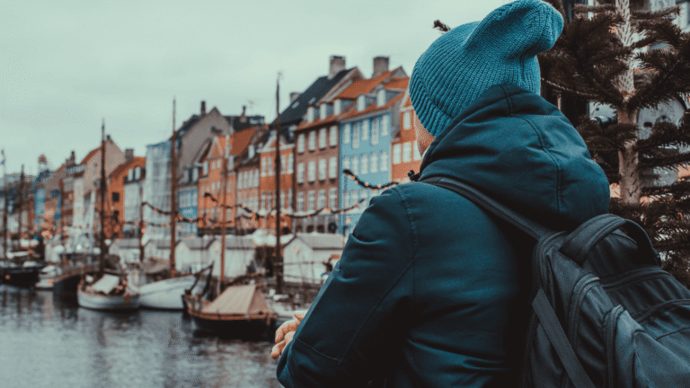 Ein Mann betrachte die bunten Häuser von Nyhavn in Kopenhagen
