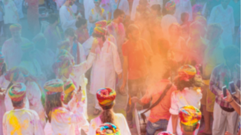 Menschen feiern farbenfroh das Holi-Fest