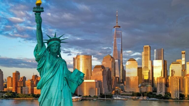 Freiheitsstatue vor der Skyline von New York bei Sonnenuntergang