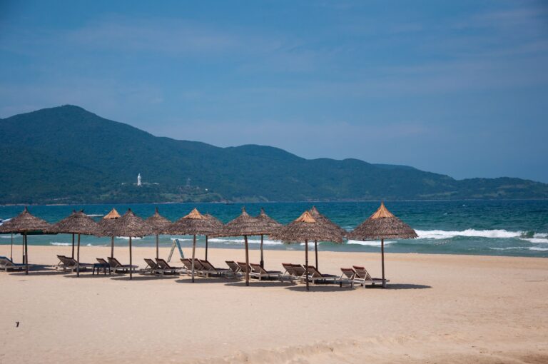 Sandstrand in Da Nang mit Sonnenschirmen und Liegen.