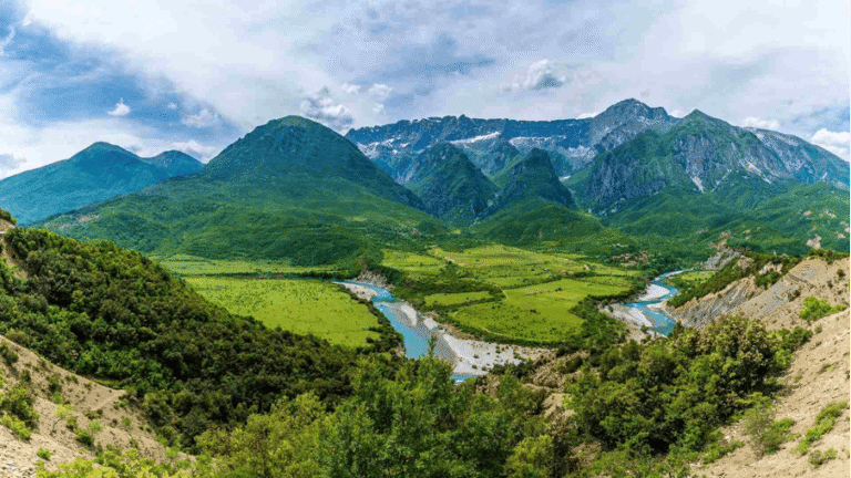 Bergpanorama in Albanien mit grünen Tälern und einem Flusslauf.
