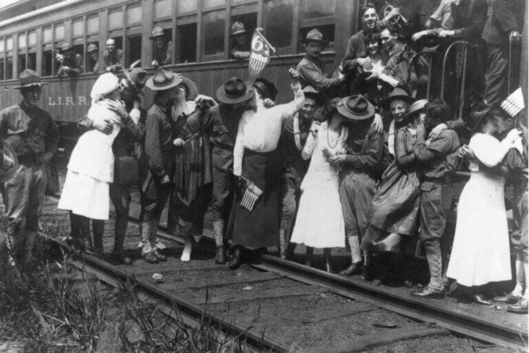 Historische Schwarz-Weiß-Aufnahme von Soldaten und Frauen, die sich auf Bahngleisen verabschieden