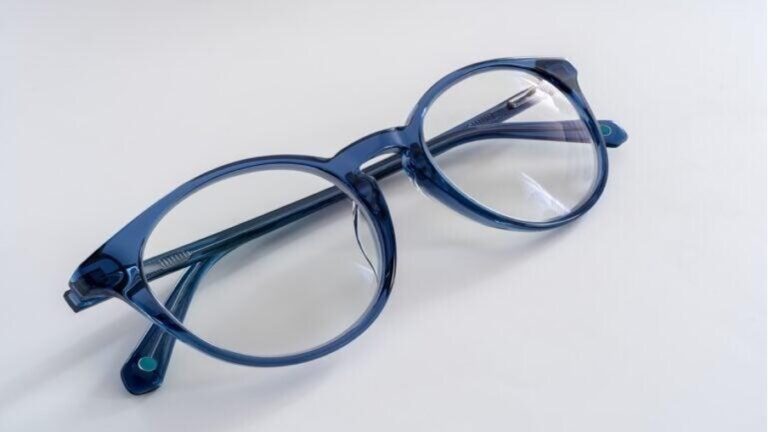 Eine moderne, rundliche Brille mit dunkelblauem, transparentem Gestell 
