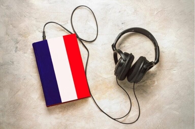 Ein Buch mit der französischen Flagge auf dem Cover, an das schwarze Kopfhörer angeschlossen sind