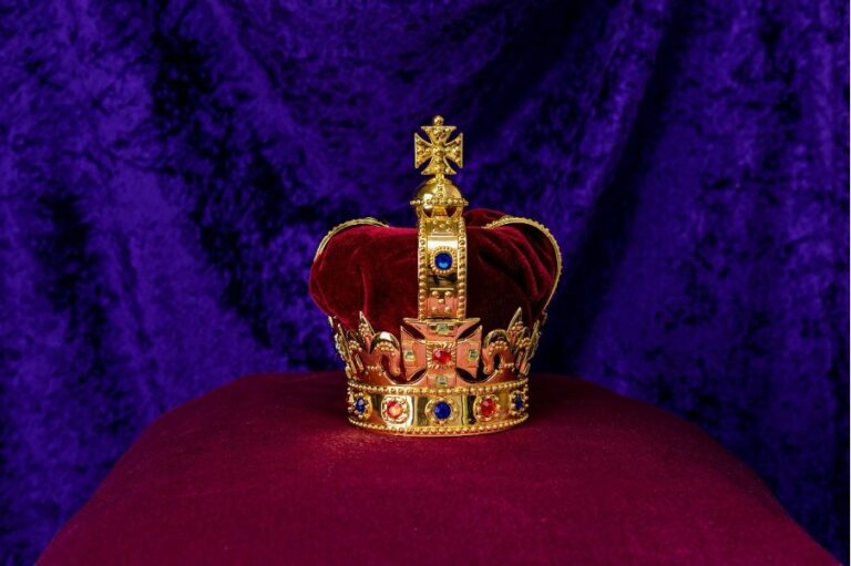 Eine goldene Königskrone mit rotem Samt und Edelsteinen.