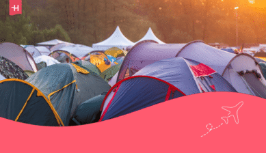 Zahlreiche bunte Zelte auf einem Festival-Campingplatz im warmen Abendlicht