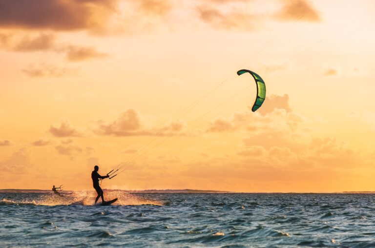 Kitesurfer auf dem Wasser vor Mauritius bei Sonnenuntergang.
