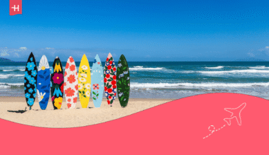 Bunte Surfbretter im Sand vor blauem Meer als Repräsentation für schönste Strände Vietnam.