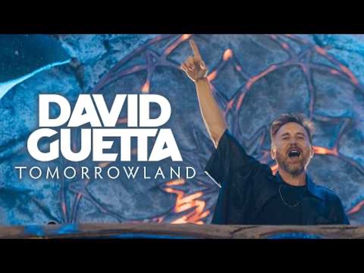 David Guetta jubelt mit erhobenem Arm vor einer aufwendig gestalteten Tomorrowland-Bühne