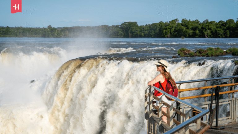Eine Frau blickt auf Wassermassen der Iguazú-Wasserfälle.  