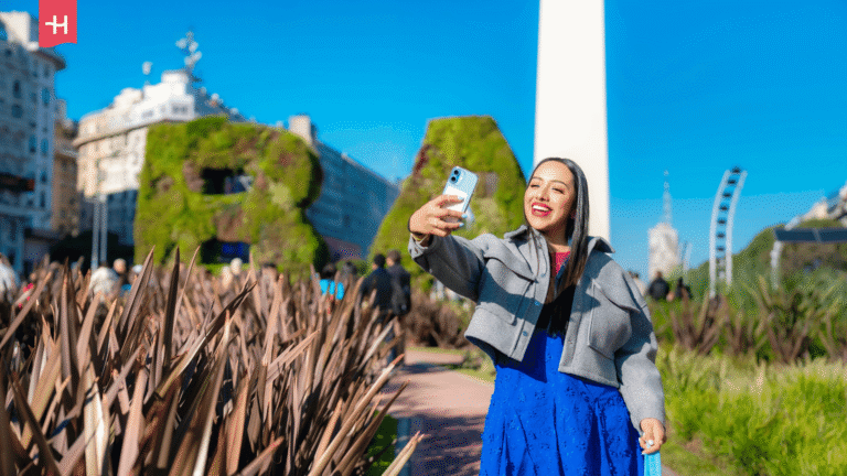 Eine lächelnde Frau macht ein Selfie auf dem Plaza de la República in Buenos Aires, Argentinien.