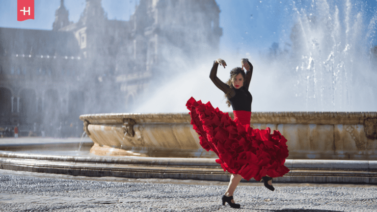 Eine Flamenco-Tänzerin vor einer großen Springbrunnen-Anlage.