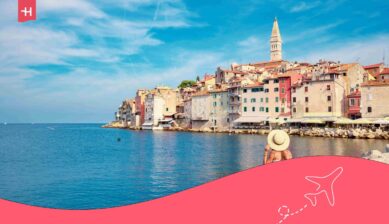 Eine Frau mit Strohhut blickt auf die Altstadt von Rovinj. Passend zum Thema: Kroatien Urlaub mit Kindern.
