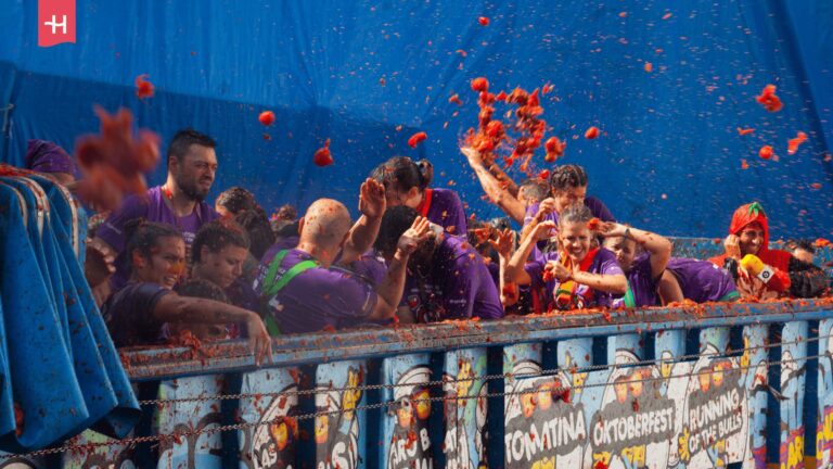 Eine Gruppe von Menschen feiert ausgelassen während des Tomatenfestivals La Tomatina. 