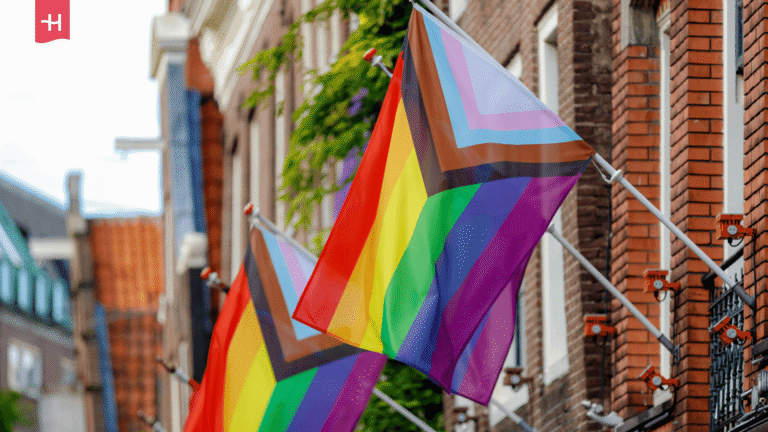 Mehrere Pride-Flaggen wehen an Fahnenmasten in Amsterdam. 