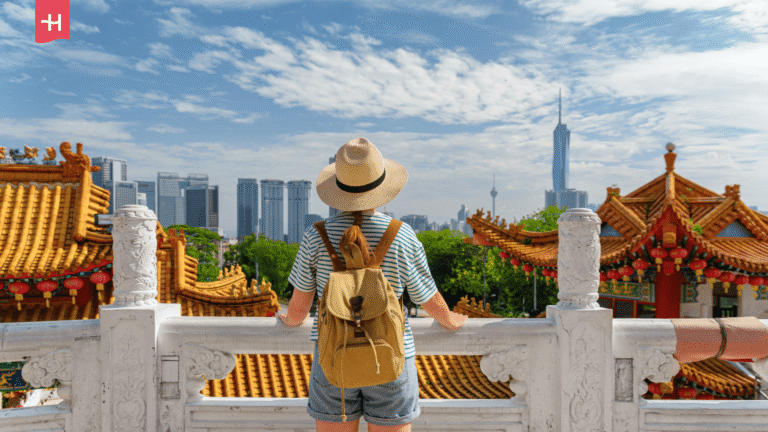 Eine Touristin blickt vom Thean Hou Tempel auf die Skyline von Kuala Lumpur.
