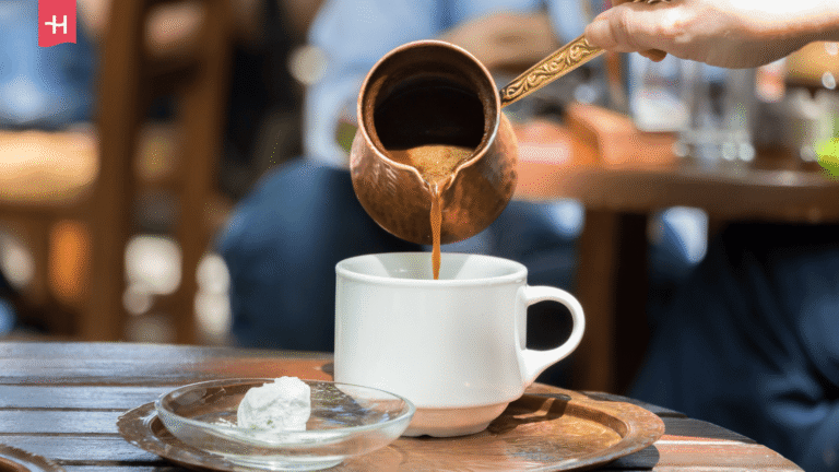 Griechischer Kaffee wird aus einem Kupferkännchen (Briki) in eine Tasse eingegossen.