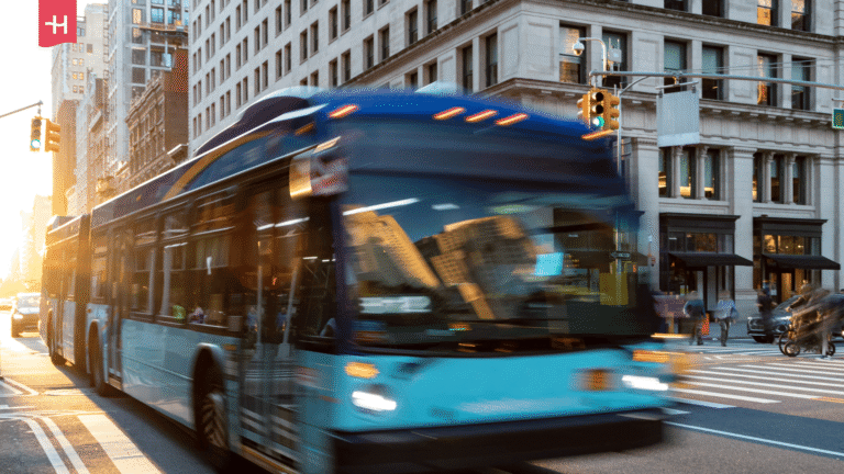 Blau-weißer Linienbus fährt durch die Straßen von New York.