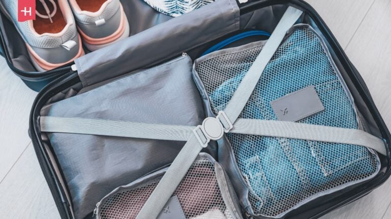 Offener Koffer mit grauen Packing Cubes.