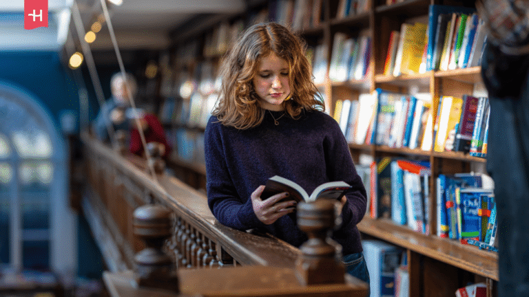 Junge Frau liest ein Buch in einer Buchhandlung