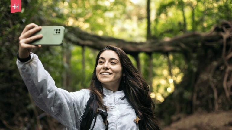 Frau macht ein Selfie beim Wandern im Wald