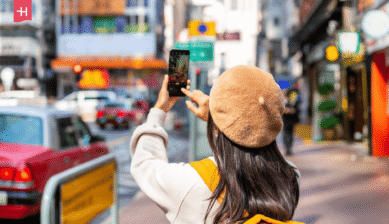 Frau fotografiert eine Straße in Hongkong