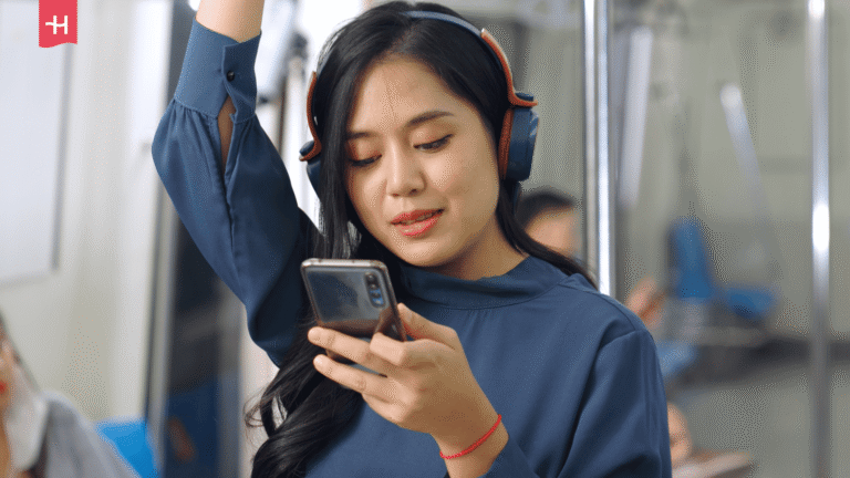 Frau mit Smartphone und Kopfhörern in der U-Bahn