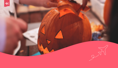 Eine Person hebt den Deckel von einem Halloween-Kürbis
