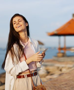 eSIM Bali datos ilimitados con mujer en la playa con su celular sonriendo