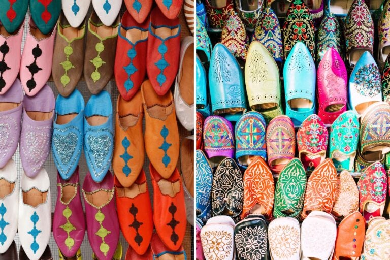 Babuchas marroquíes de cuero en varios colores y diseños, exhibidas en un mercado.