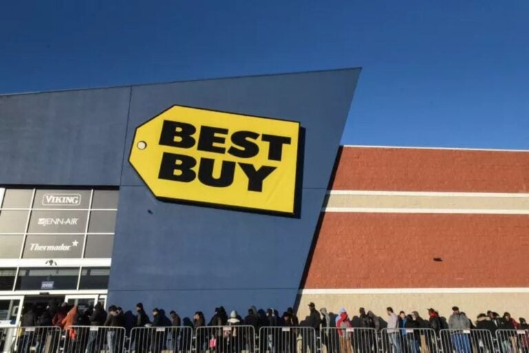 Fachada de la tienda con el logo de Best Buy y personas haciendo fila.