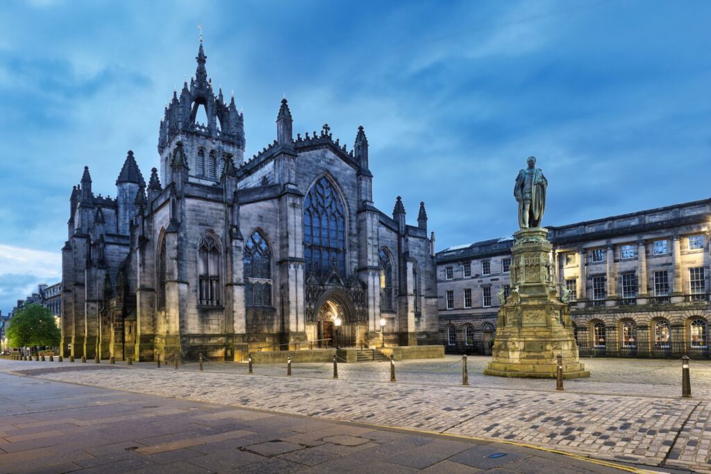 Vista de la Catedral de St Giles en Edimburgo con su imponente arquitectura gótica, iluminada al anochecer.