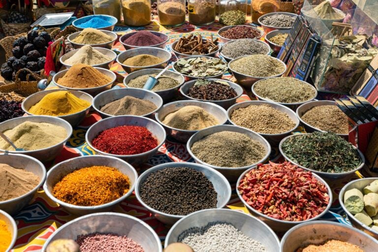 Variedad de especias egipcias coloridas y aromáticas, exhibidas en cuencos de metal en un mercado tradicional.