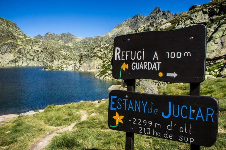 Letreros informativos en el lago de Juclar con datos sobre el refugio y el lago.