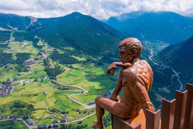 Mirador Roc del Quer en Andorra sobre una plataforma con vistas a las montañas y la escultura de un pensador.
