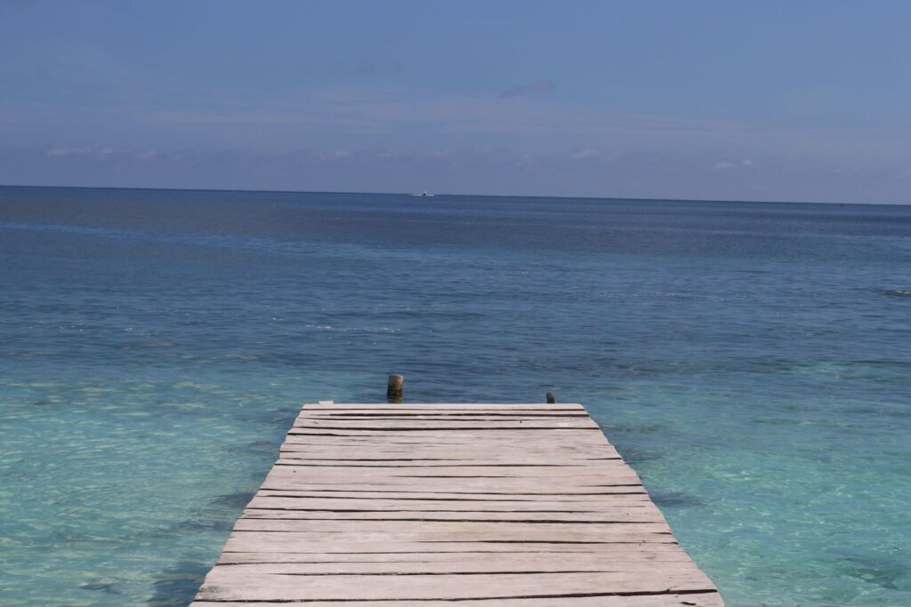 Muelle de madera sobre mar cristalino en la isla Tintipán, Colombia.