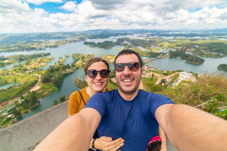 Turistas disfrutando de la vista panorámica desde una zona segura en el embalse de Guatapé, Colombia.