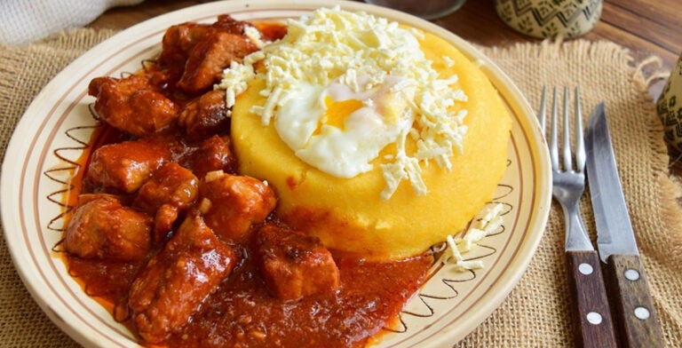 Tochitura, guiso de carne servido con polenta y huevo frito