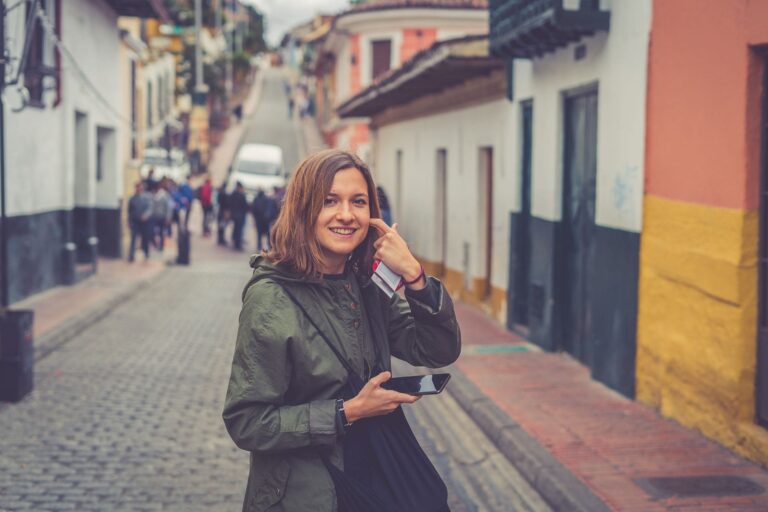Mujer joven sonriendo en calle empedrada de Bogotá, Colombia.