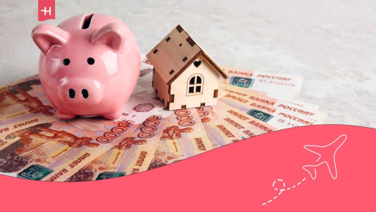Dinero ruso y un cerdito en forma de hucha con una casa de madera al lado.