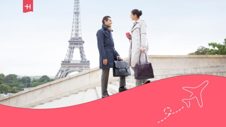 Una pareja de empresarios hablando y detrás la Torre Eiffel.