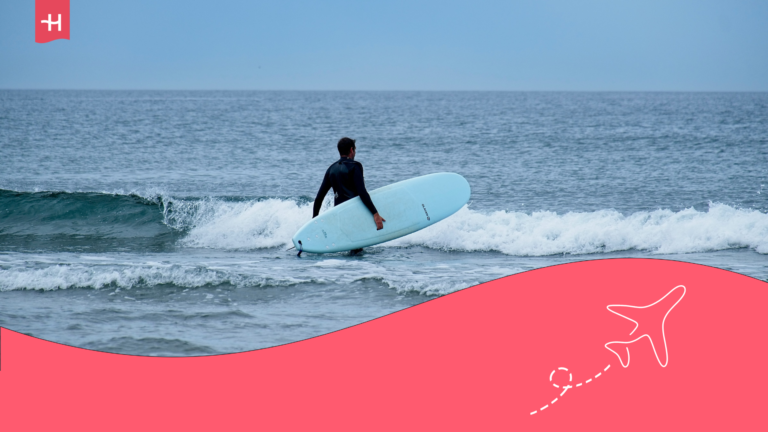 Persona entrando al mar con una table de surf en Famara