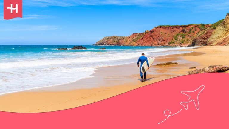 Hombre con tabla de surf en la mano en una playa de Portugal