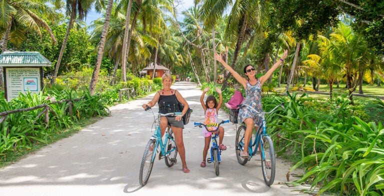 Turistas recorriendo en bicicleta la isla de La Digue en Seychelles.