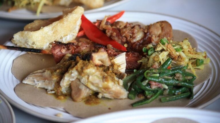 Babi guling balinés con piel crujiente, arroz al vapor y verduras
