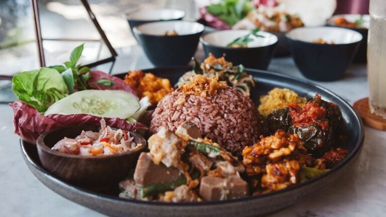 Nasi campur con arroz al vapor y variedad de pequeños platos balineses
