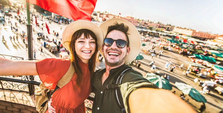 Pareja visitando el mercado de Jamaa el-Fna en Marrakech, Marruecos