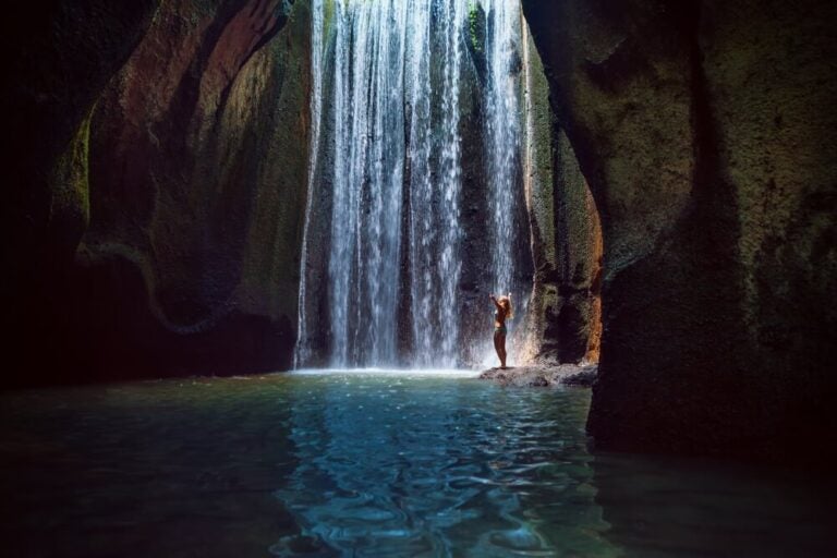 En la Cascada Tukad Cepung el agua cae a través de una grieta estrecha en la roca, dando la sensación de estar oculta en el centro de la tierra.