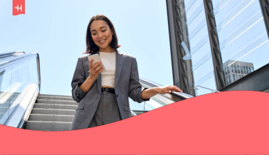 Profesional consultando su móvil mientras baja por unas escaleras mecánicas, imagen del artículo sobre los planes de Holafly for Business.