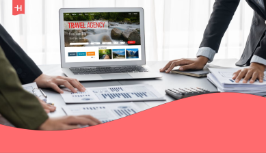 Profesionales revisando documentos y una página web de reservas de viajes en un ordenador portátil, para ilustrar qué es una agencia de viajes de negocios.